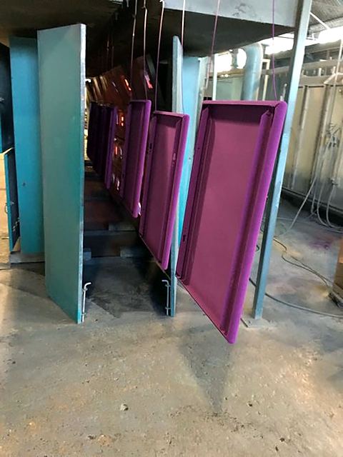 Metal panels finished in purple hanging on the coating line